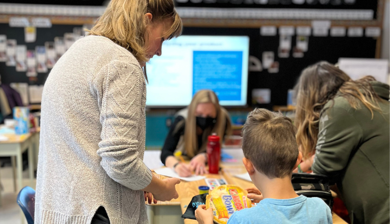 Rethinking waste coordinator working with student during classroom presentation.